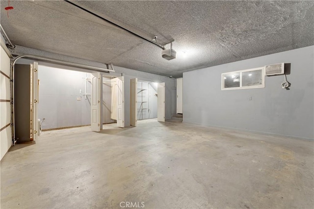 garage with a wall mounted air conditioner and a garage door opener