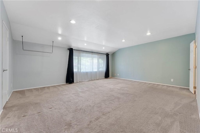 carpeted empty room featuring lofted ceiling