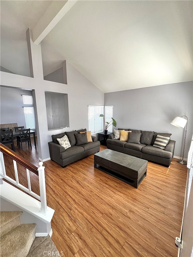 living room with light hardwood / wood-style flooring and high vaulted ceiling