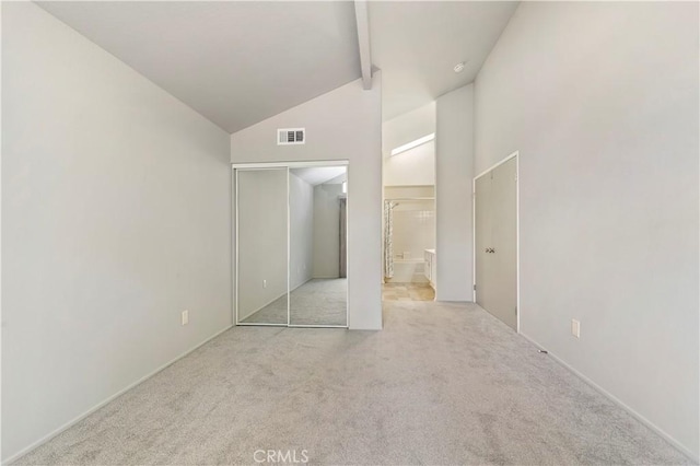 unfurnished bedroom with high vaulted ceiling, beam ceiling, light carpet, and a closet