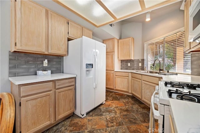 kitchen featuring light brown cabinetry, sink, white appliances, and tasteful backsplash