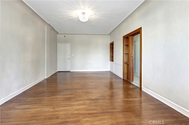 unfurnished room with dark wood-type flooring