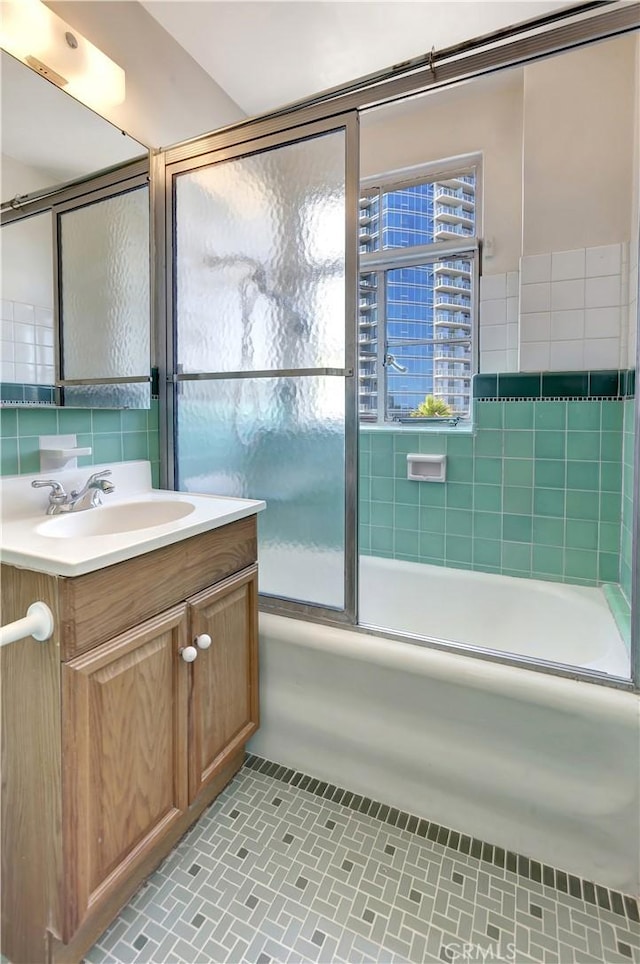 bathroom featuring tile patterned floors, vanity, bath / shower combo with glass door, and tasteful backsplash