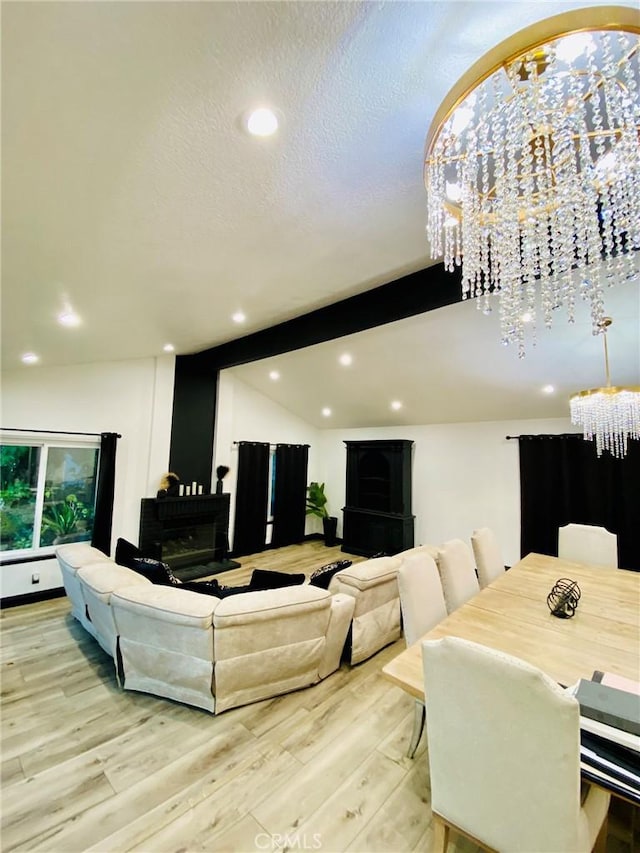 living room featuring light wood-type flooring, an inviting chandelier, and vaulted ceiling