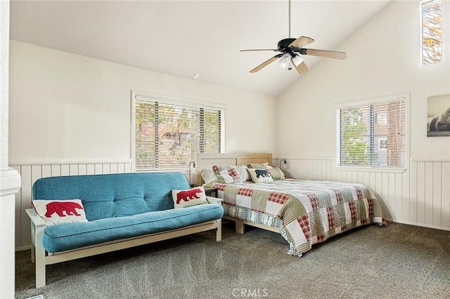 carpeted bedroom featuring high vaulted ceiling, ceiling fan, and wooden walls