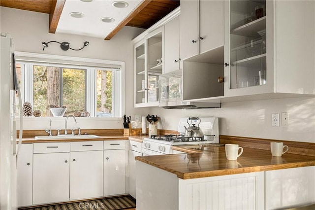 kitchen with white cabinetry, sink, beamed ceiling, kitchen peninsula, and white appliances