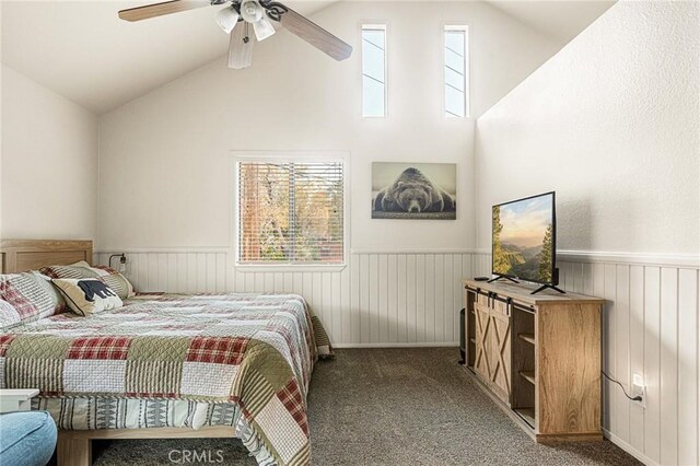 carpeted bedroom featuring vaulted ceiling, ceiling fan, and wooden walls