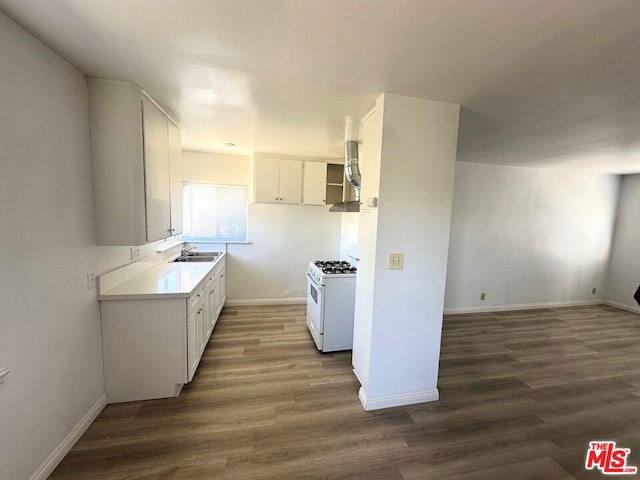 kitchen with wall chimney exhaust hood, white cabinets, white range with gas cooktop, and dark hardwood / wood-style flooring