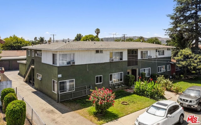 view of front facade with a balcony and a front yard