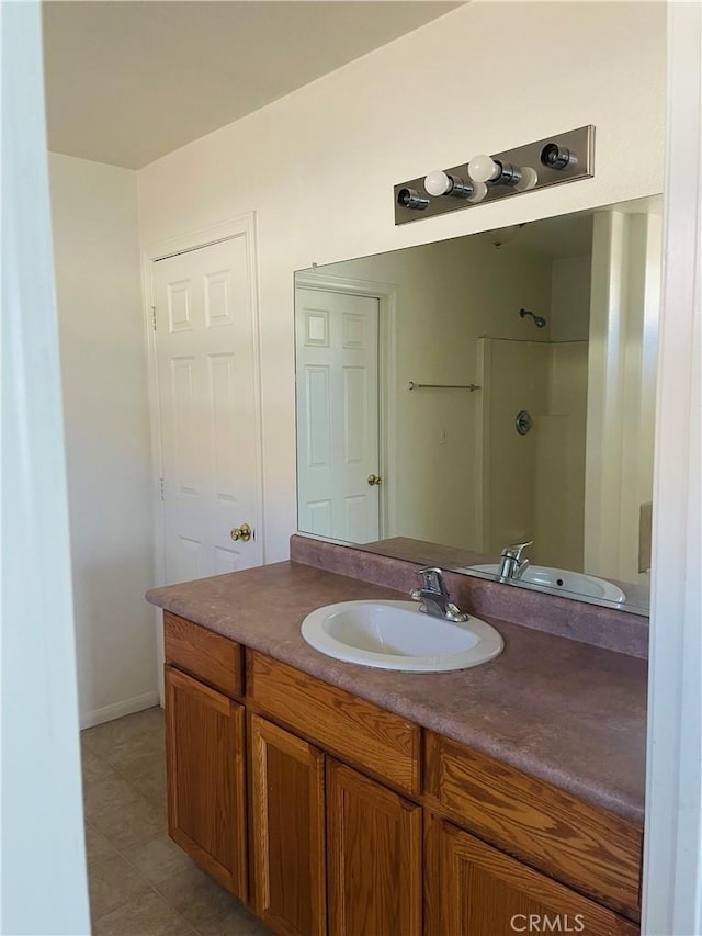 bathroom with vanity, tile patterned flooring, and a shower