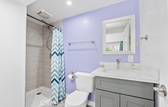 bathroom with walk in shower, vanity, and toilet