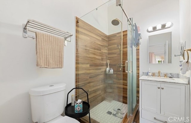 bathroom featuring vanity, toilet, and a shower with shower door