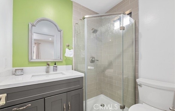 bathroom with vanity, a shower with shower door, and toilet