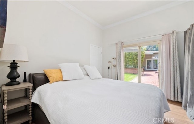 bedroom with light hardwood / wood-style floors, ornamental molding, and access to exterior