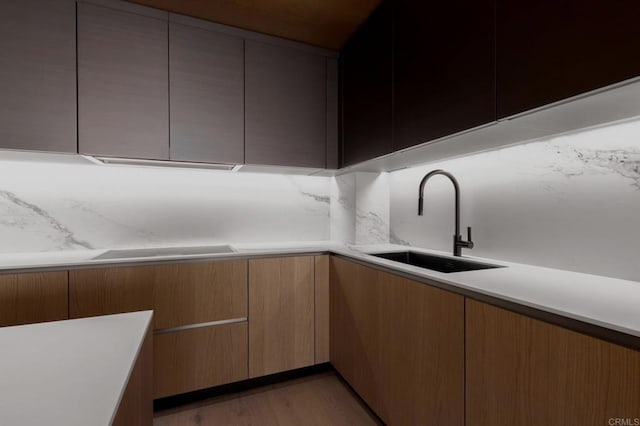 kitchen featuring light wood-type flooring, stovetop, and sink