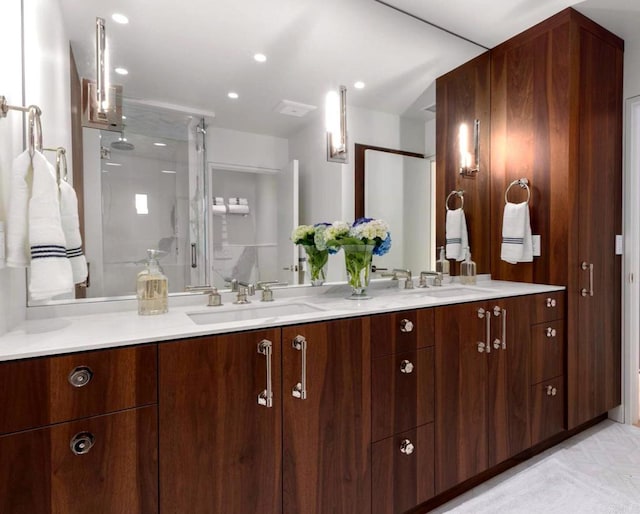 bathroom featuring a shower with door and vanity