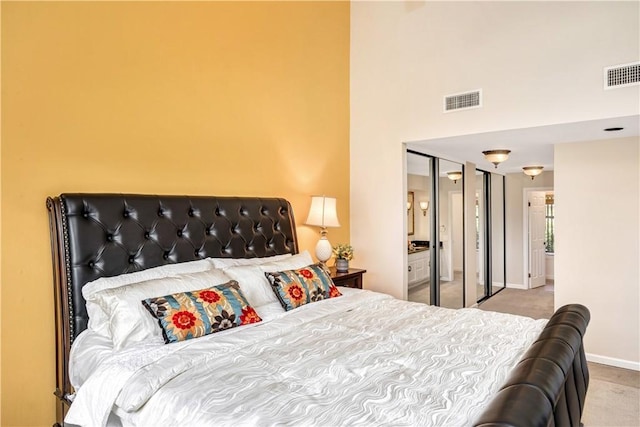 carpeted bedroom with a high ceiling and a closet