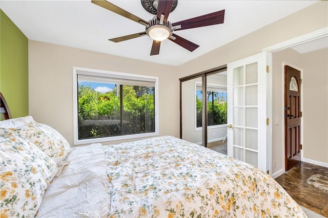 bedroom with ceiling fan, a closet, dark wood-type flooring, and multiple windows