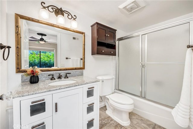 full bathroom featuring vanity, shower / bath combination with glass door, tile patterned flooring, ceiling fan, and toilet