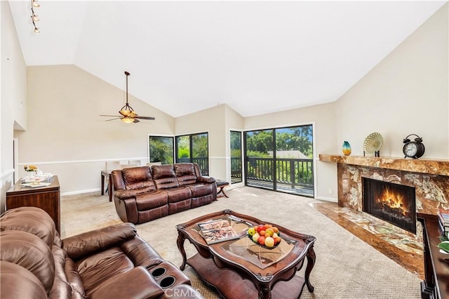 carpeted living room featuring a fireplace, high vaulted ceiling, and ceiling fan