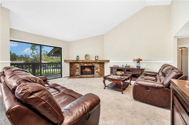 living room with high vaulted ceiling, light carpet, and a high end fireplace