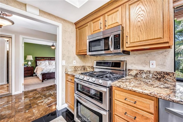 kitchen featuring stainless steel appliances and light stone counters