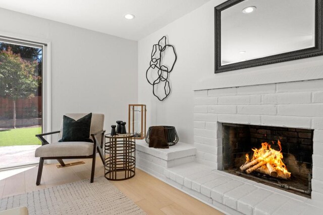 sitting room featuring hardwood / wood-style flooring, plenty of natural light, and a fireplace