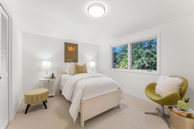 bedroom with light carpet and a closet