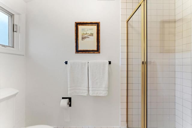 bathroom featuring toilet and an enclosed shower