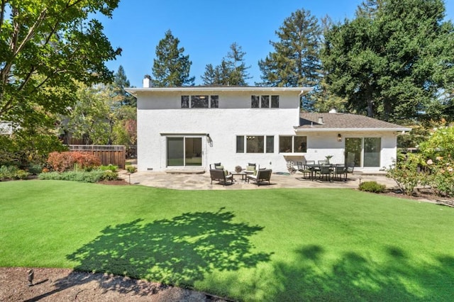 back of house featuring a patio area and a lawn