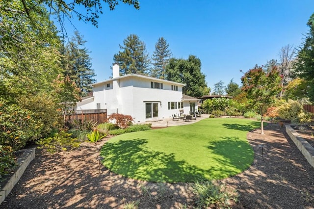 rear view of property with a yard and a patio area