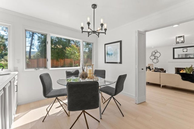 dining space featuring light hardwood / wood-style flooring, ornamental molding, and a healthy amount of sunlight