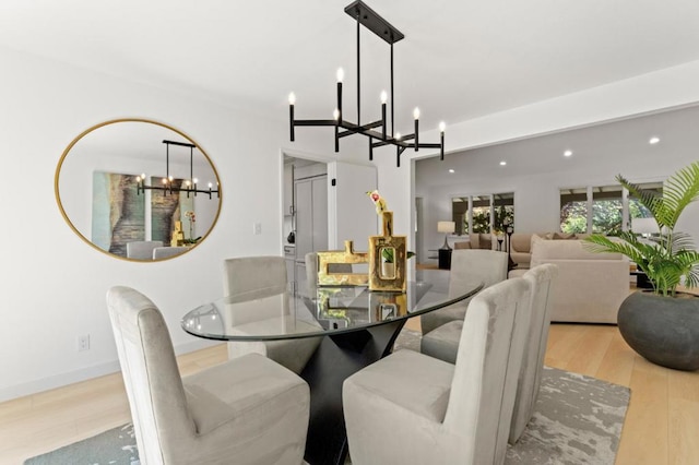 dining area featuring an inviting chandelier and light hardwood / wood-style floors