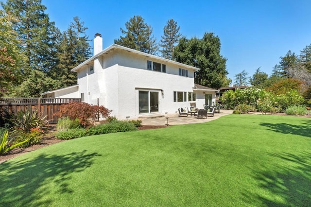 rear view of property featuring a patio area and a lawn