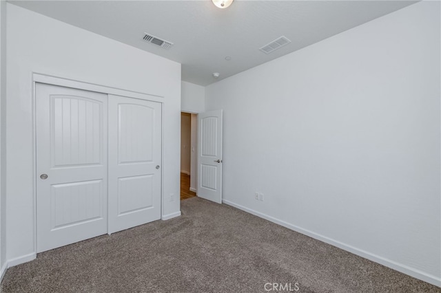 unfurnished bedroom featuring carpet flooring and a closet