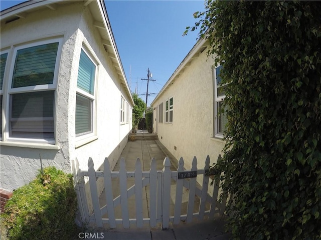 view of property exterior with fence and stucco siding