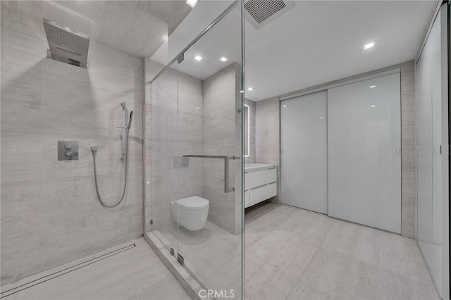 bathroom with vanity, an enclosed shower, tile walls, and toilet