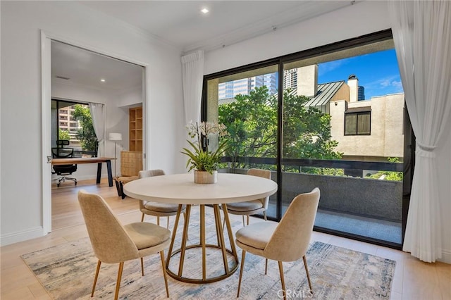 dining space featuring light hardwood / wood-style floors and ornamental molding