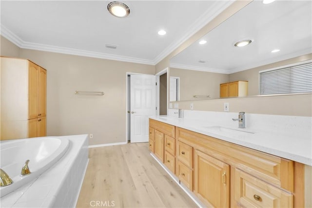 bathroom featuring hardwood / wood-style flooring, vanity, crown molding, and tiled tub