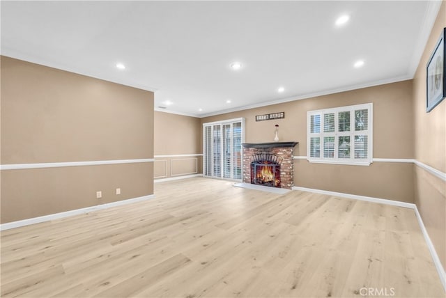 unfurnished living room with a fireplace, light hardwood / wood-style flooring, and ornamental molding