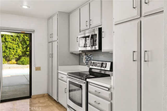 kitchen with white cabinetry, stainless steel appliances, and backsplash