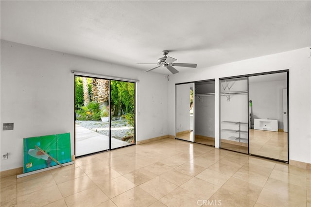 unfurnished bedroom featuring multiple closets, access to outside, ceiling fan, and light tile patterned floors