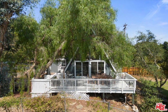 rear view of house featuring a wooden deck