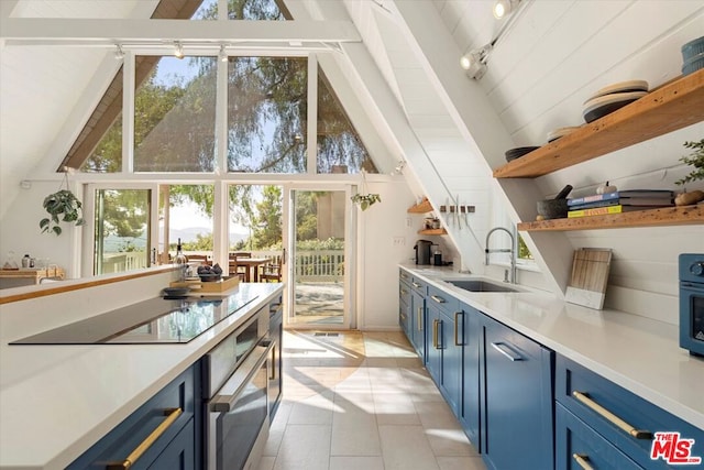 kitchen featuring a wealth of natural light, sink, lofted ceiling with beams, and blue cabinets