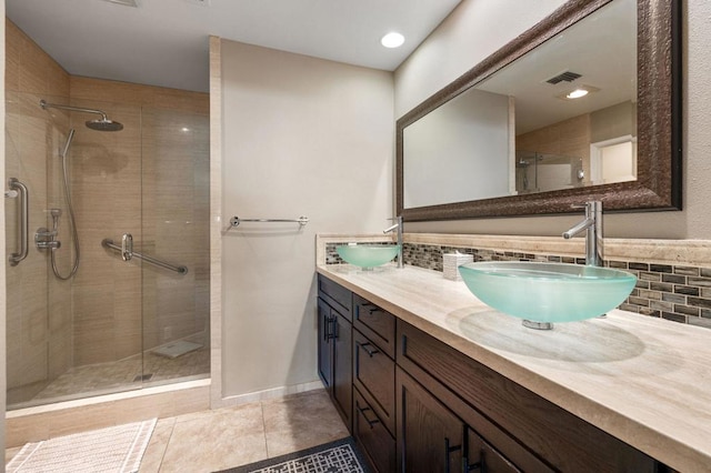 bathroom with vanity, tile patterned flooring, a shower with door, and decorative backsplash