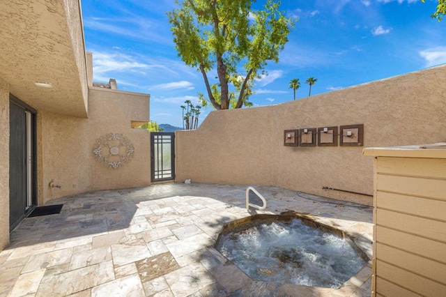 view of patio with an in ground hot tub