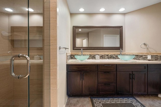 bathroom with vanity, an enclosed shower, and backsplash