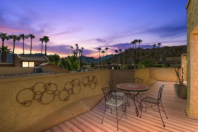 deck at dusk featuring a mountain view