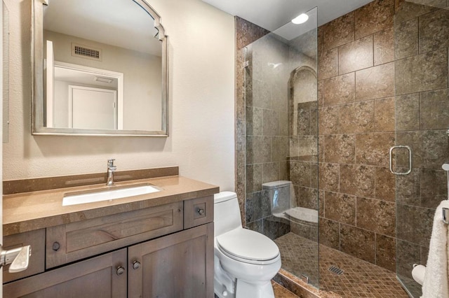 bathroom featuring vanity, toilet, and an enclosed shower