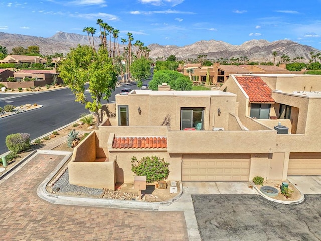 view of front of home featuring a balcony, a garage, and a mountain view